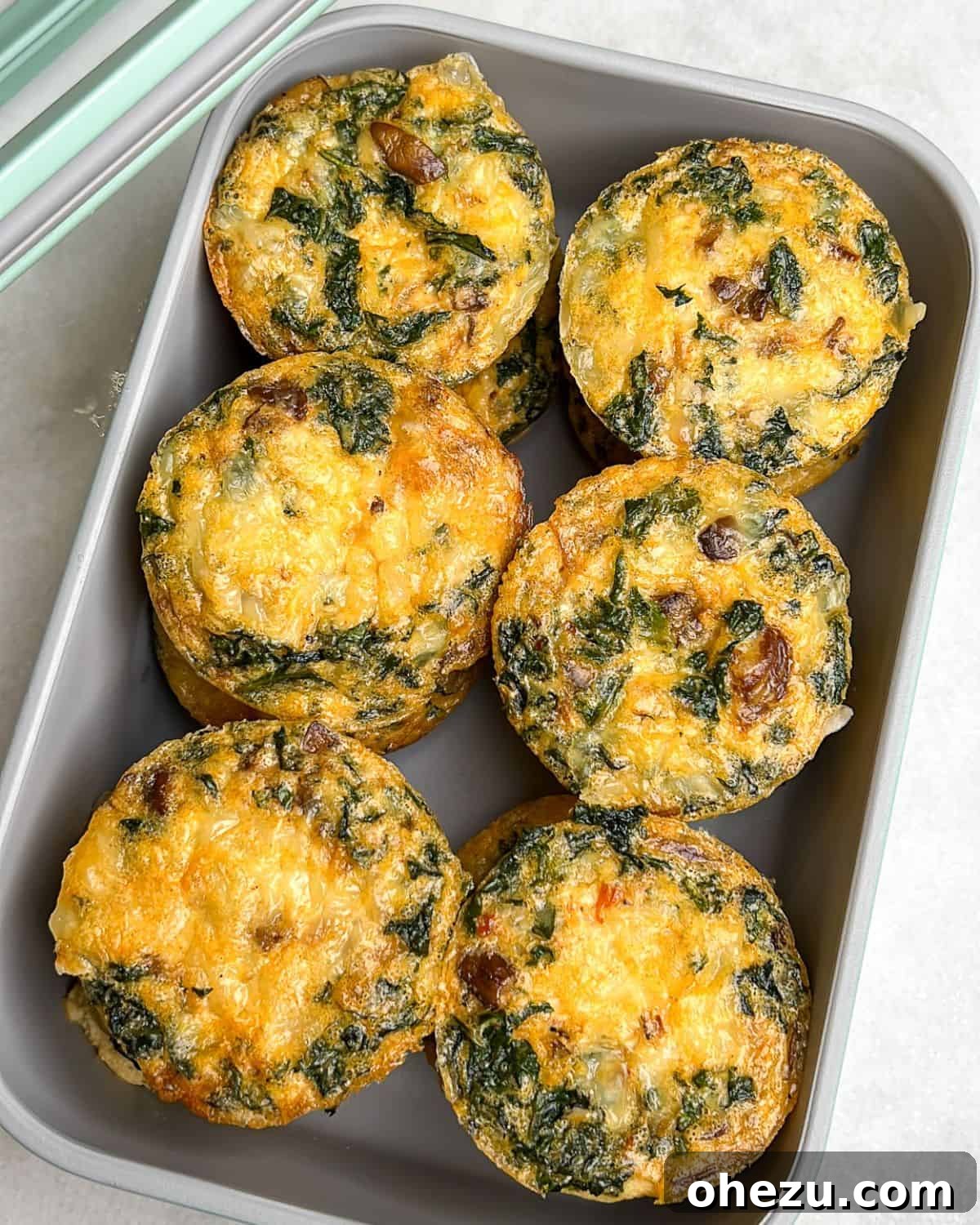 Conveniently store and meal prep your kale and mushroom egg bites in an airtight container for easy breakfasts. Homemade kale and mushroom egg bites neatly stored in a glass meal prep container.