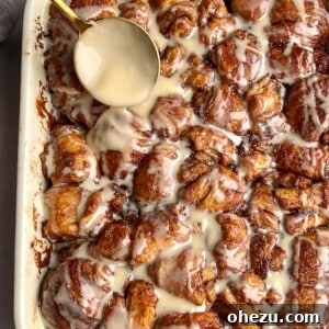 Cinnamon Roll Poppers 2 Drizzling frosting over baked cinnamon roll bites in a square dish.