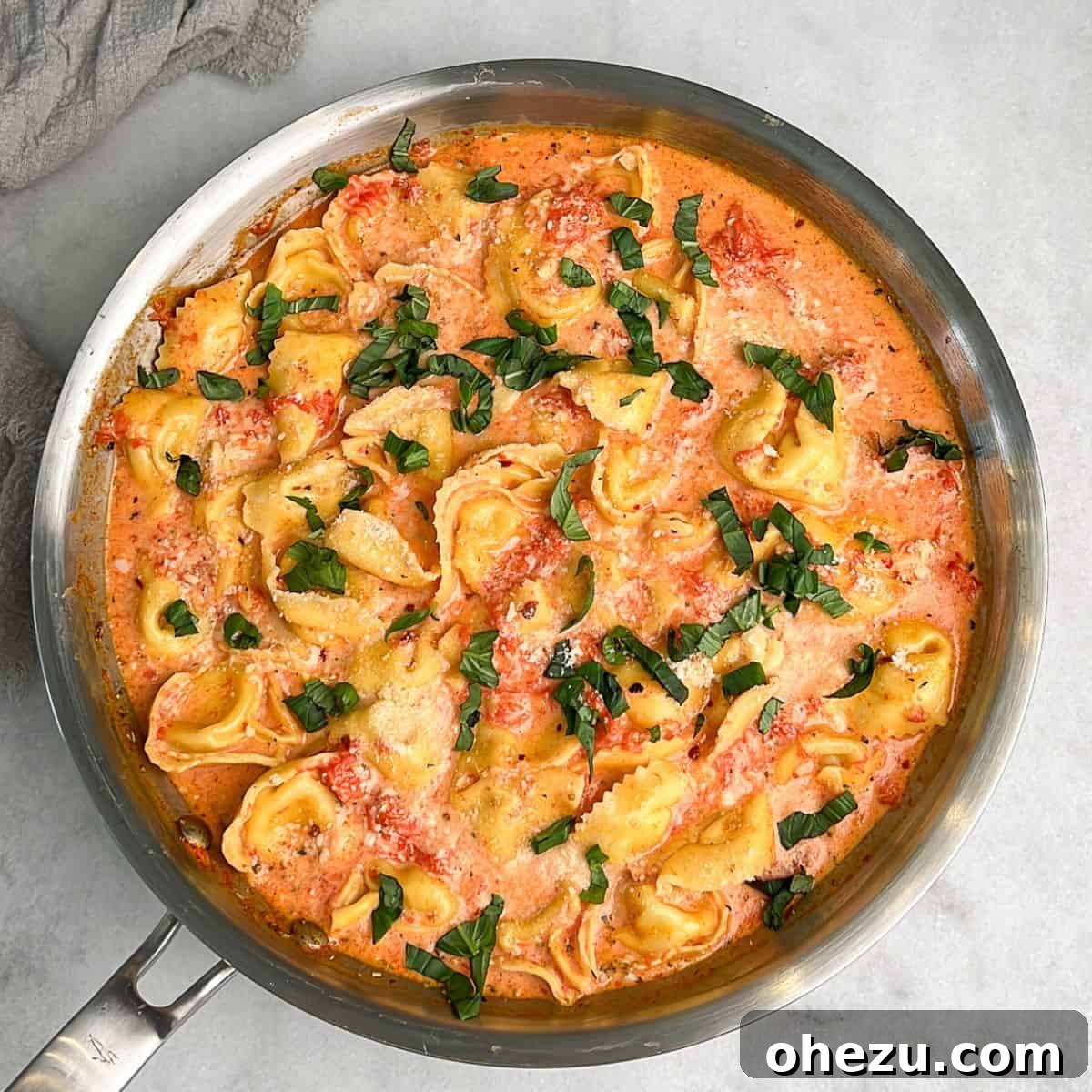 A pan filled with luscious creamy tomato tortellini, ready to be served.