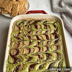 Dubai chocolate cheesecake in a casserole dish near graham crackers.