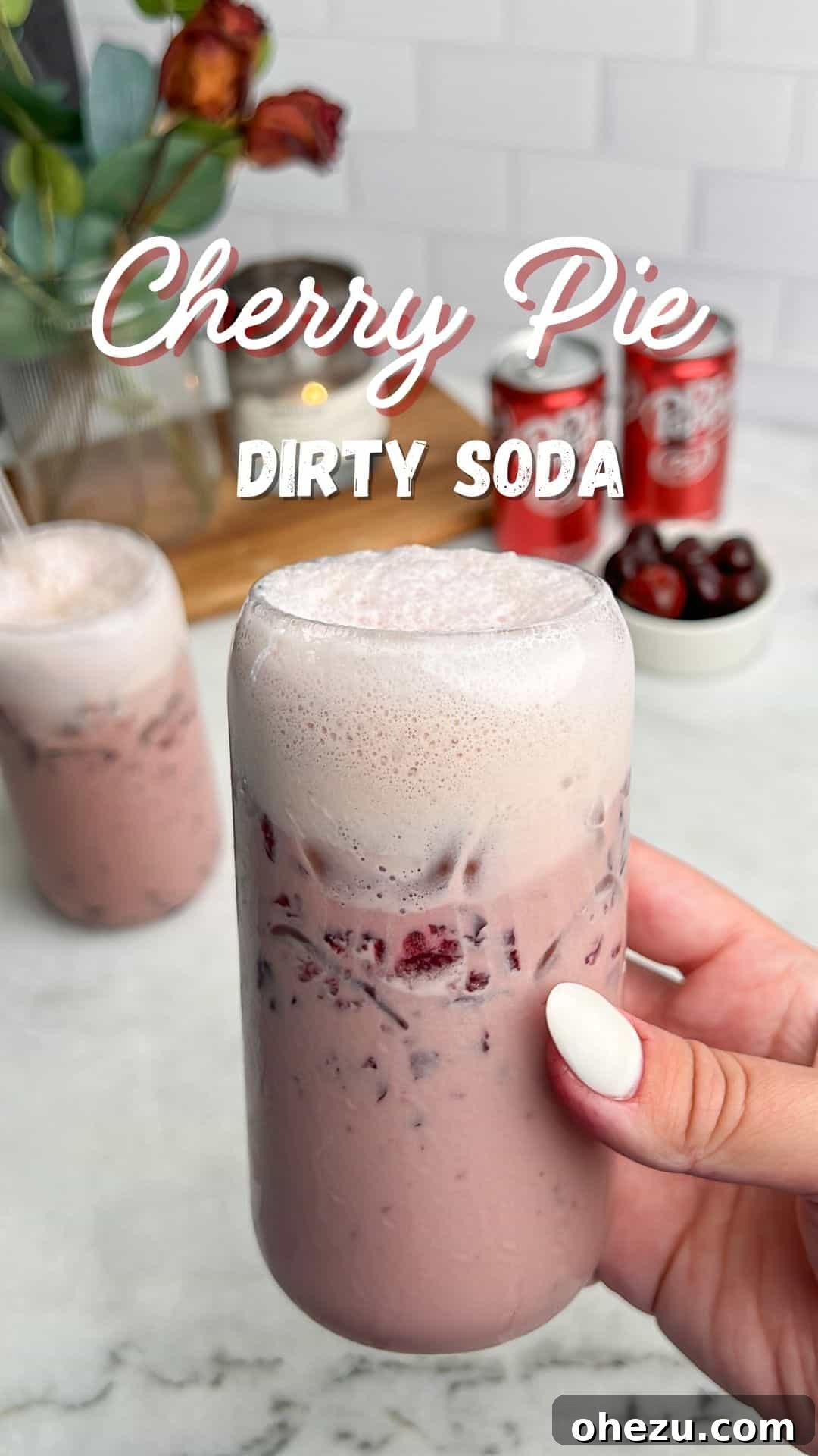 cherry vanilla drink with cold foam held in hand