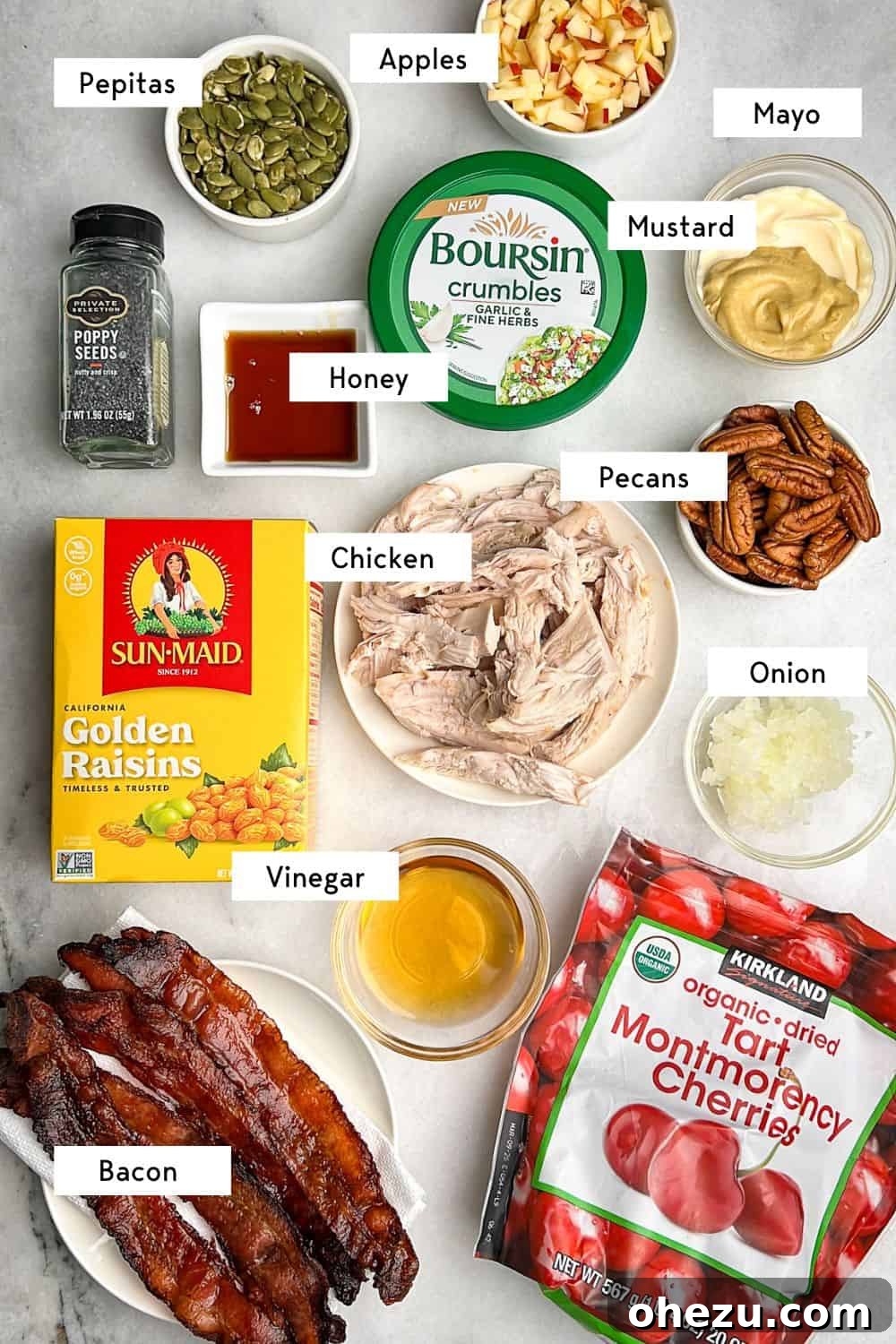 This autumn-inspired chicken salad with apples is an ideal blend of savory chicken, crisp apples, crunchy pecans, and so much more. Labeled ingredients for autumn chicken salad with apples laid out on a wooden surface.