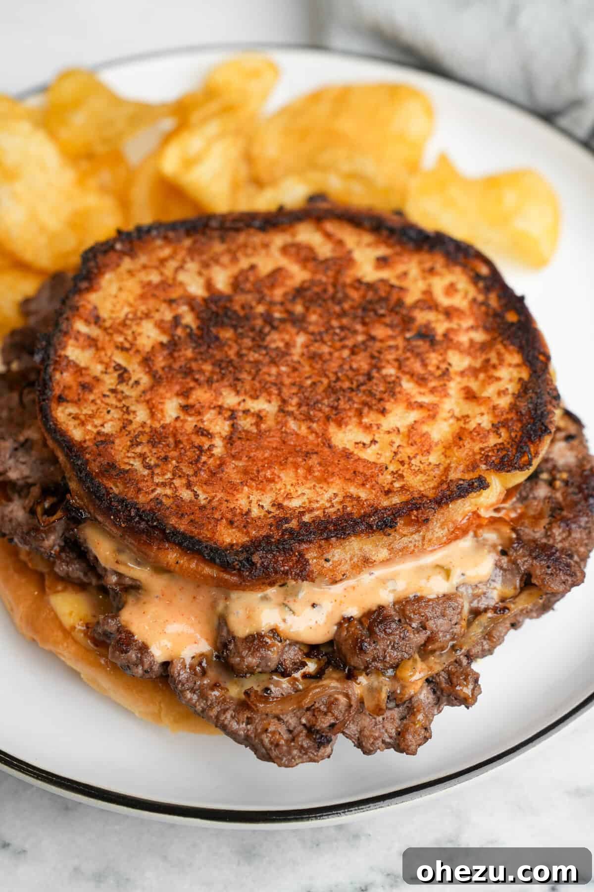 Delicious Smashburger Grilled Cheese sandwich served on a plate with crispy potato chips