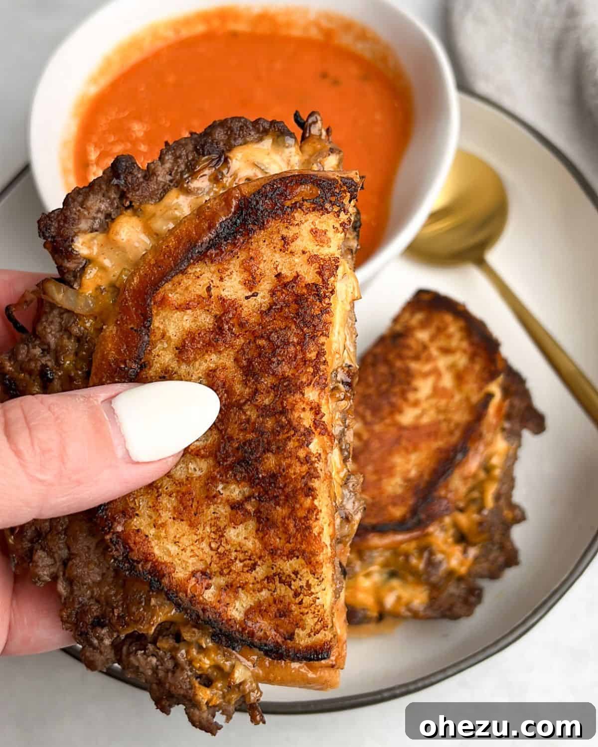 Hearty Smashburger Grilled Cheese with a side of warm tomato soup, perfect for dipping