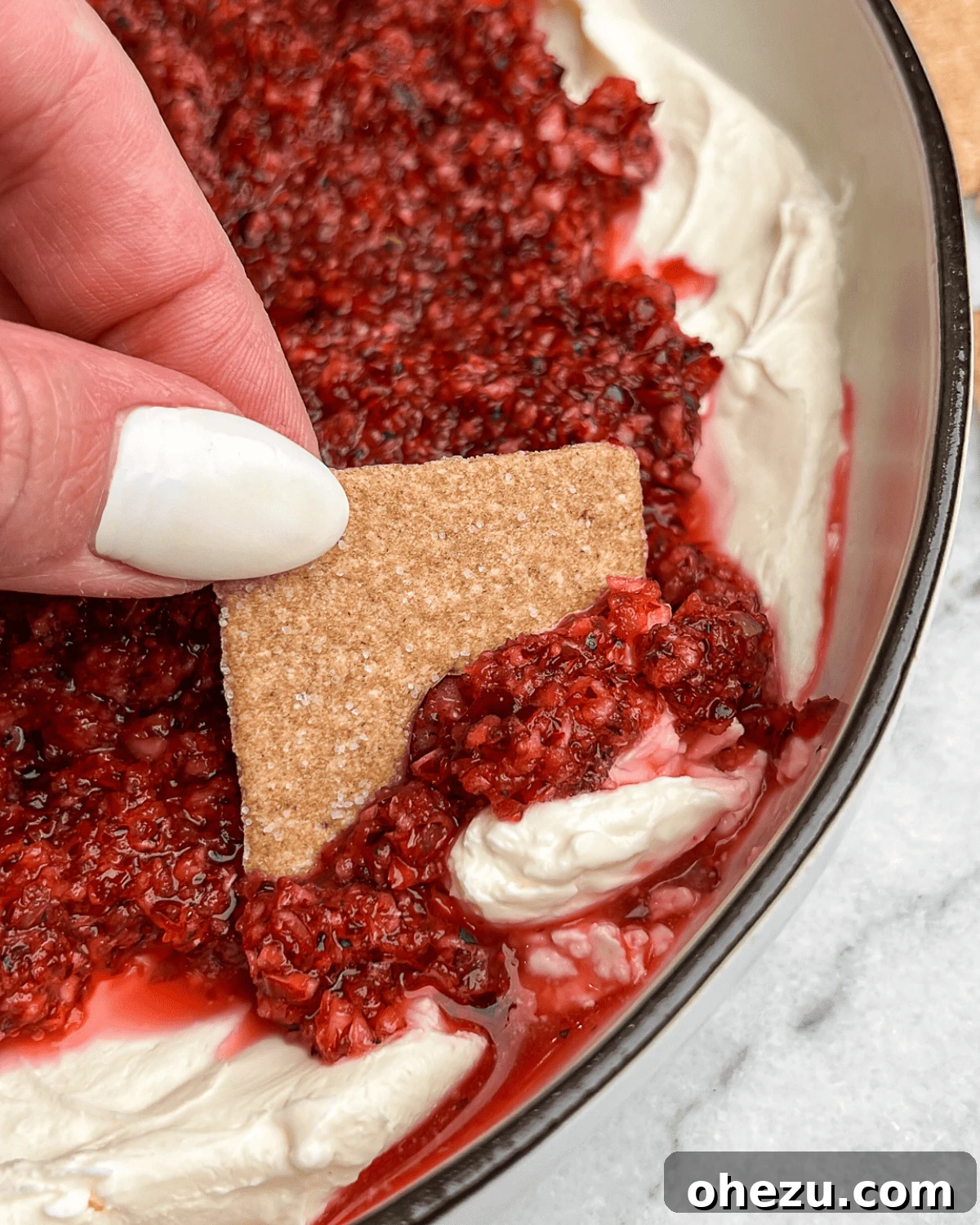 Sweet Heat Cranberry Jalapeno Dip 7 dipping a cracker into cranberry jalapeno cream cheese dip
