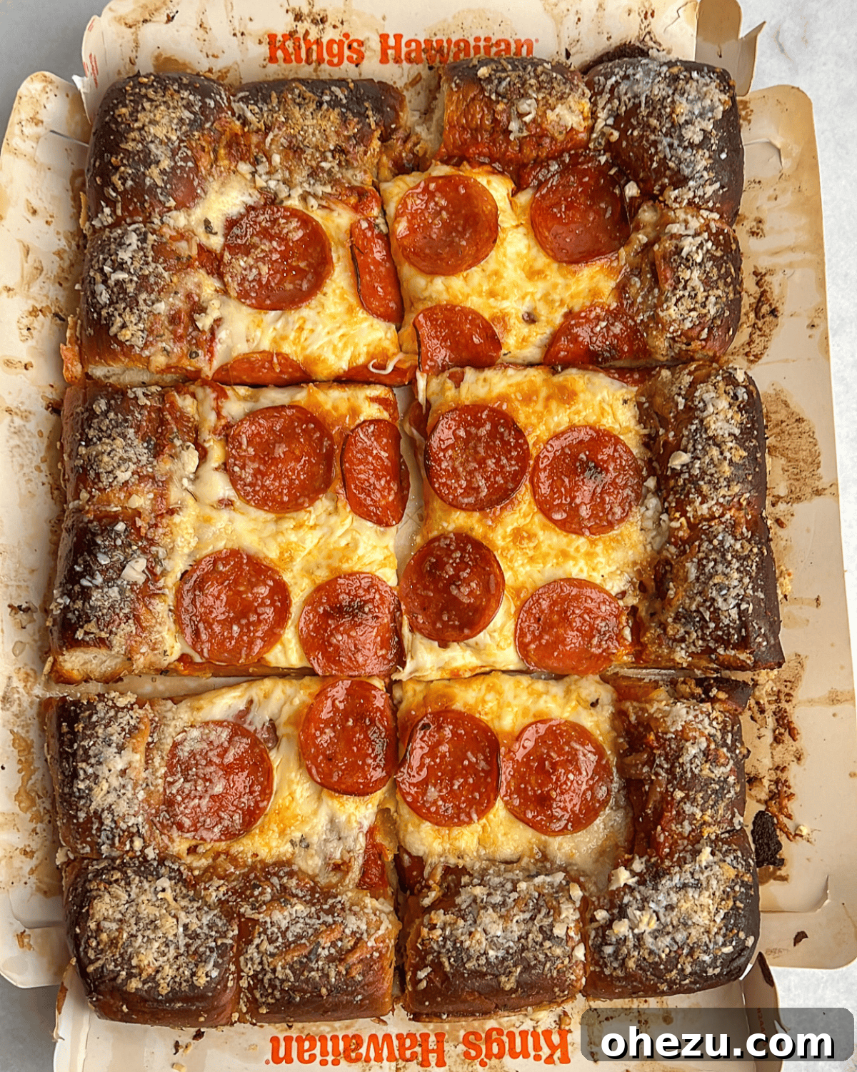 A freshly sliced pepperoni pizza made with Hawaiian rolls, ready to be served.