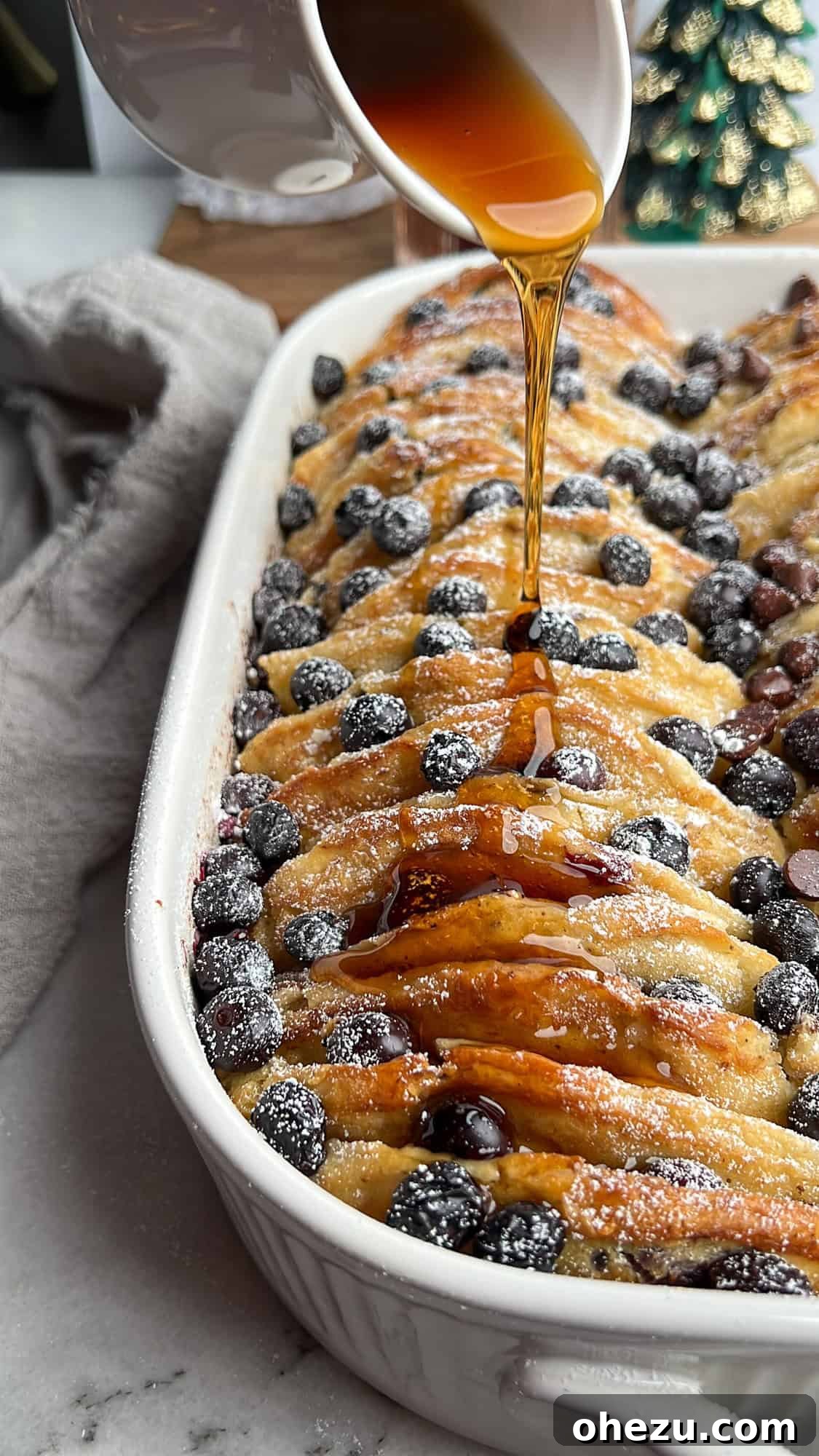 Warm pancake casserole being generously drizzled with golden maple syrup, ready to be served and enjoyed.