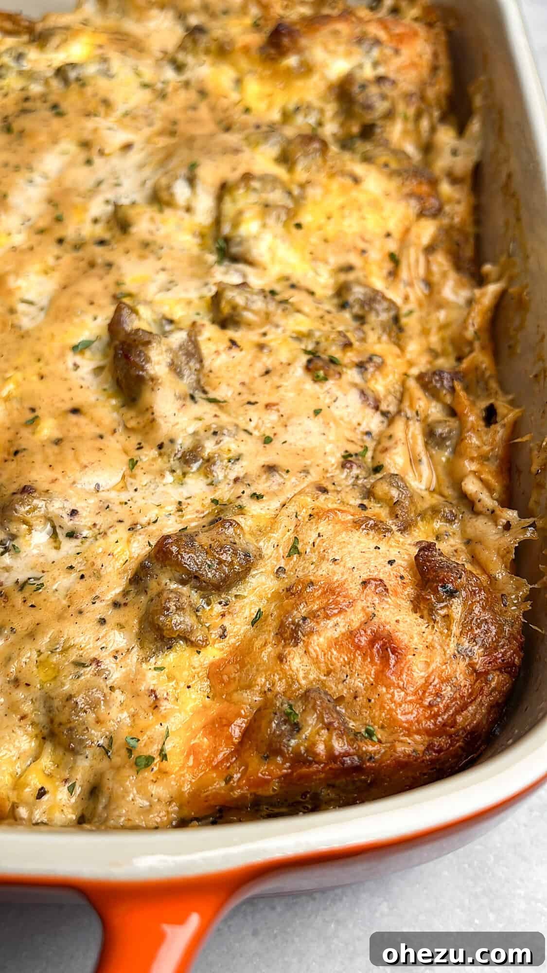 A bubbling, golden-brown breakfast casserole, fresh out of the oven, showcasing the crispy biscuit edges and rich gravy.