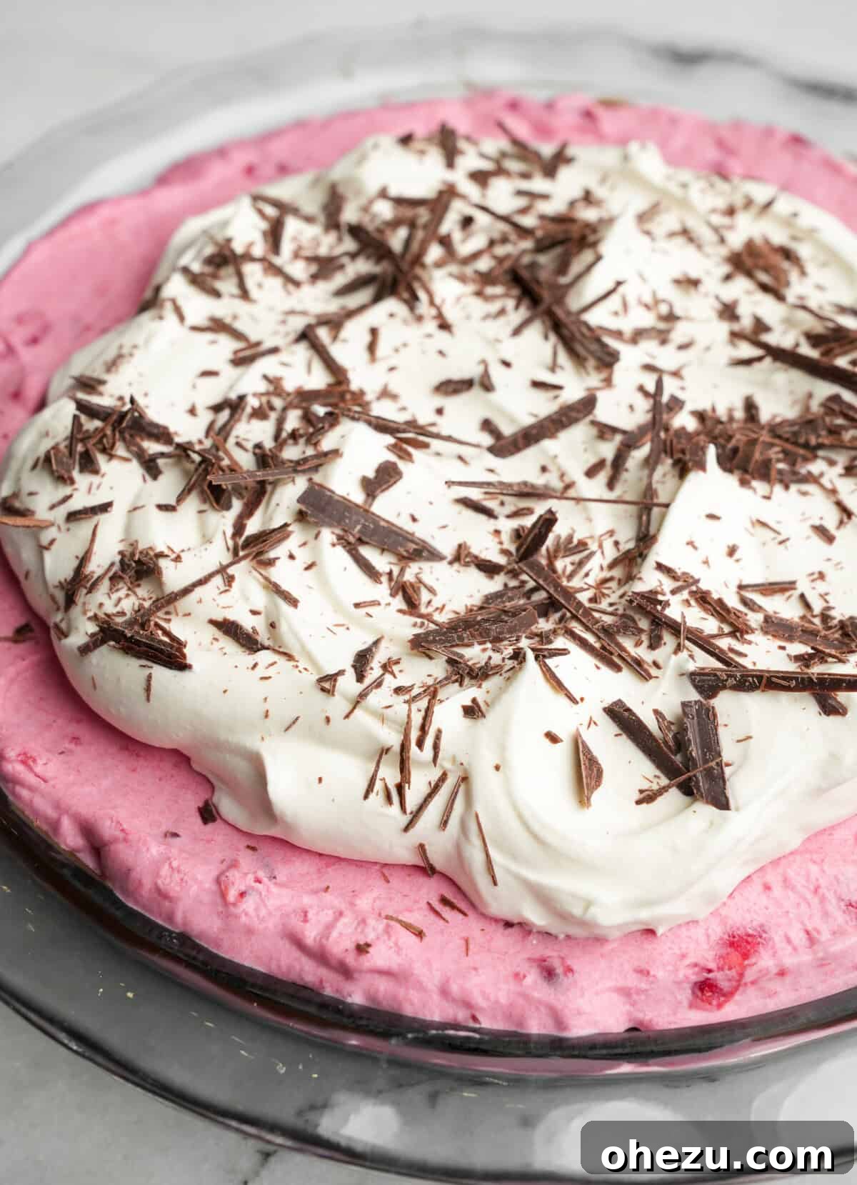 whipped cream and chocolate piled high on cranberry cream pie