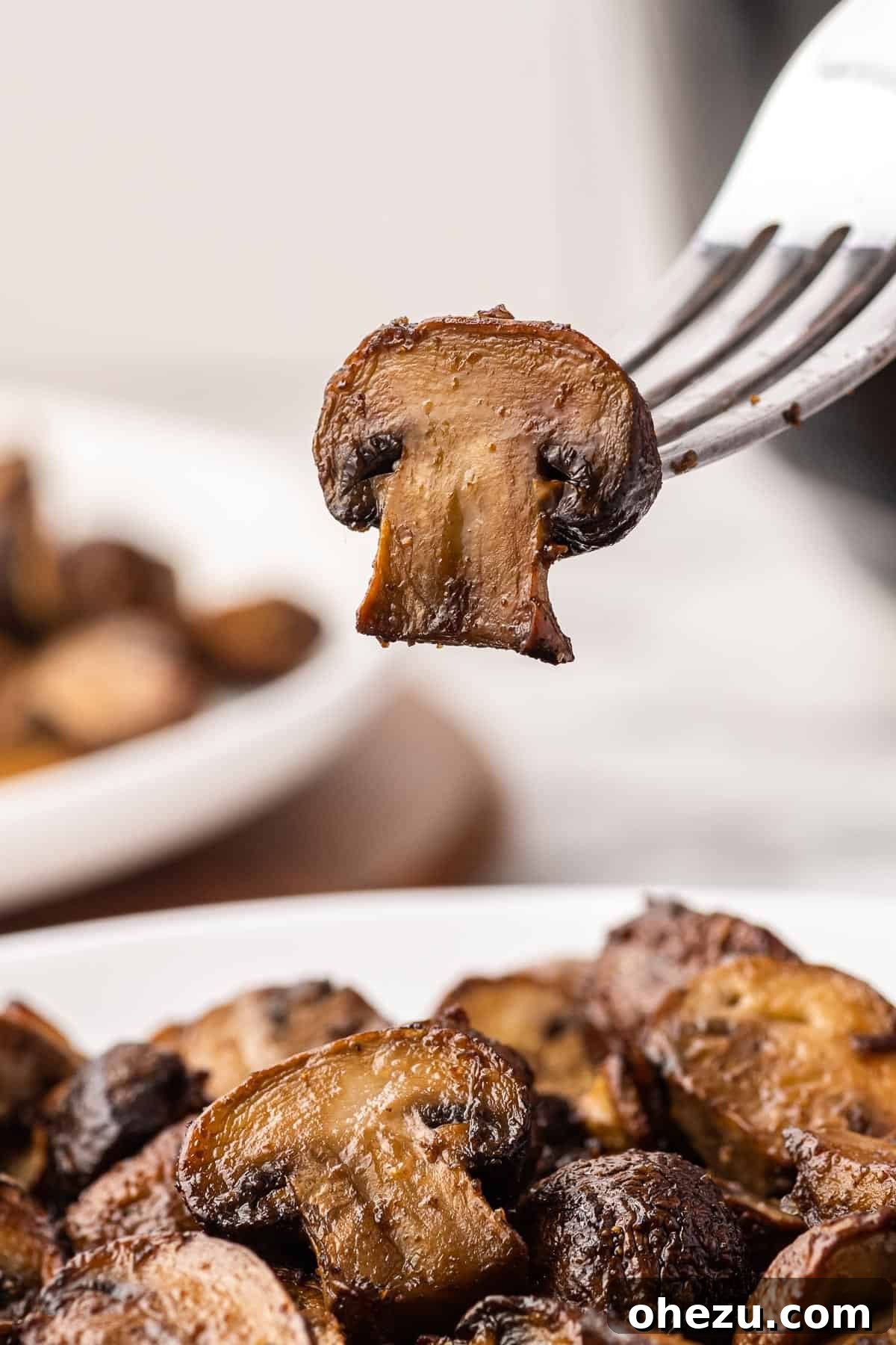 a fork holding a single perfectly cooked mushroom