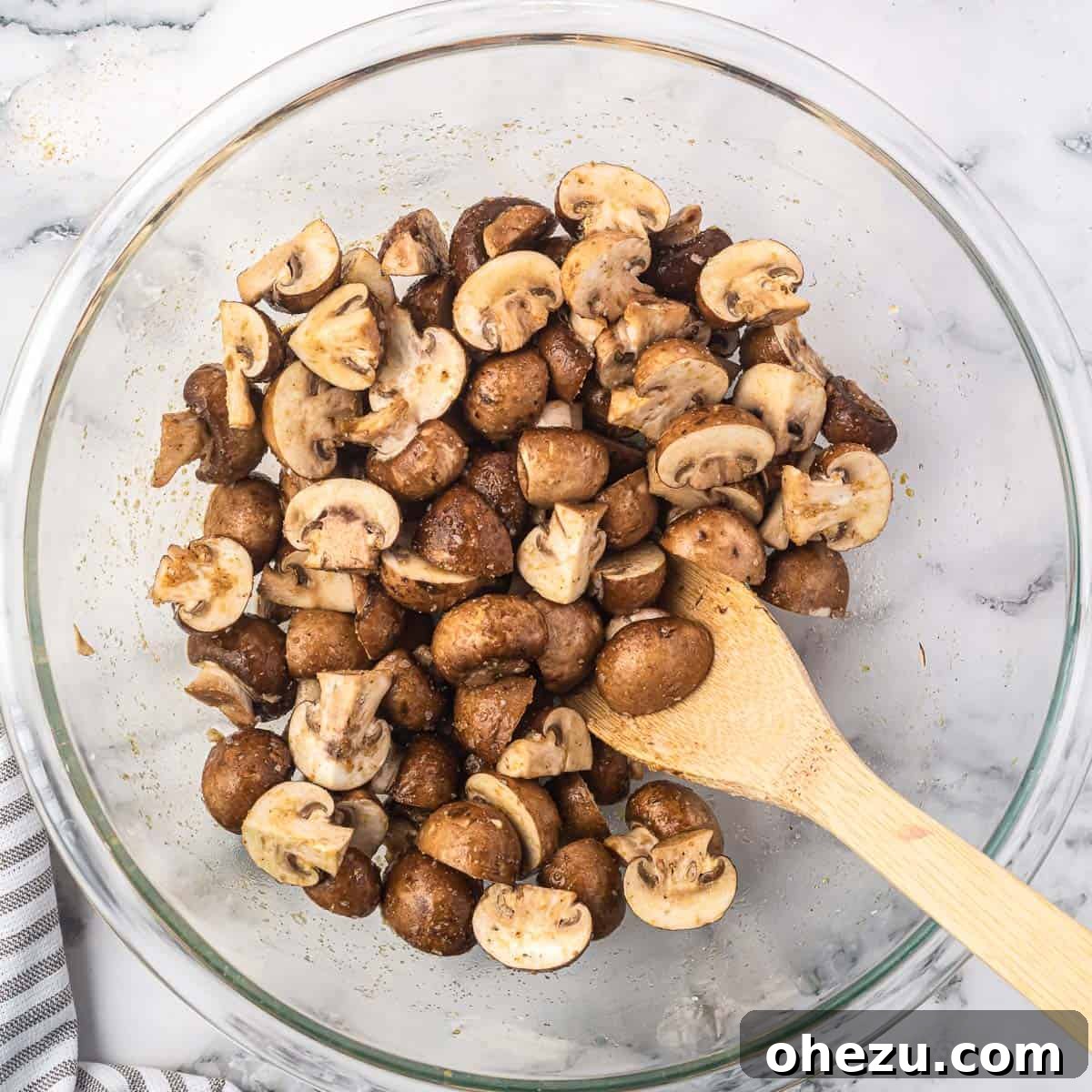 cut mushrooms in a bowl mixed together with the oil and spices