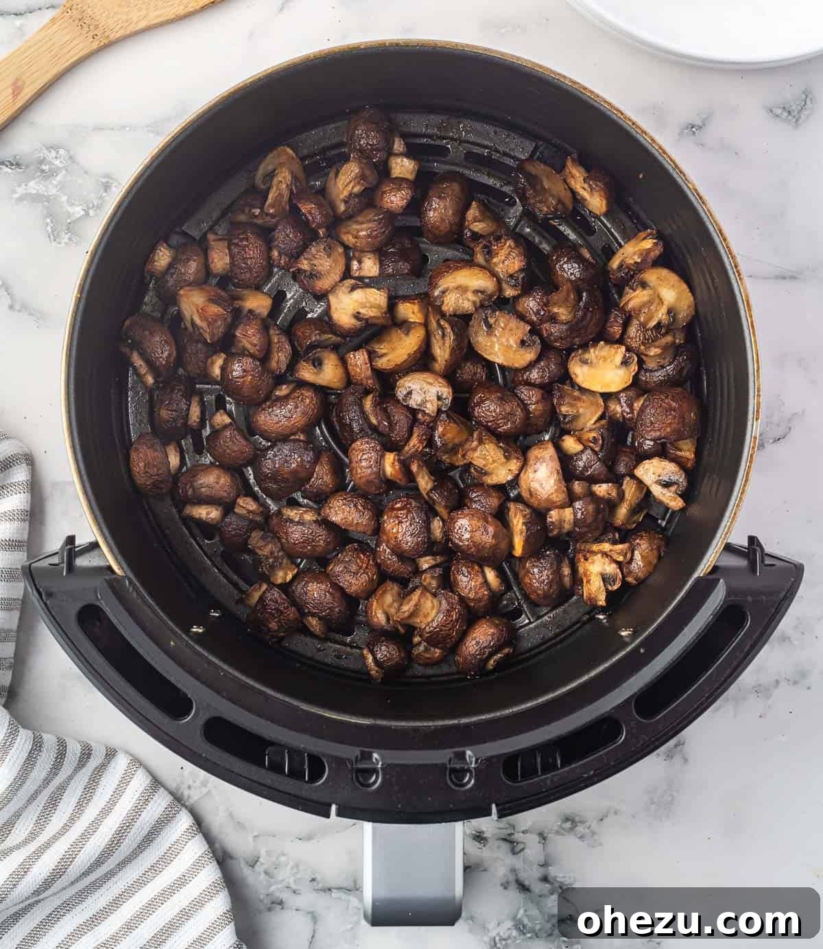 air fried mushrooms perfectly cooked and ready to serve in the air fryer basket