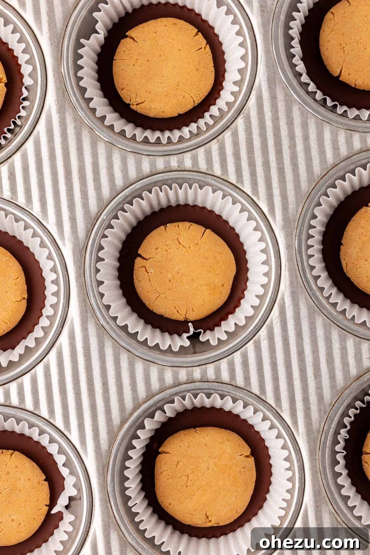 Adding the peanut butter filling over the melted chocolate base