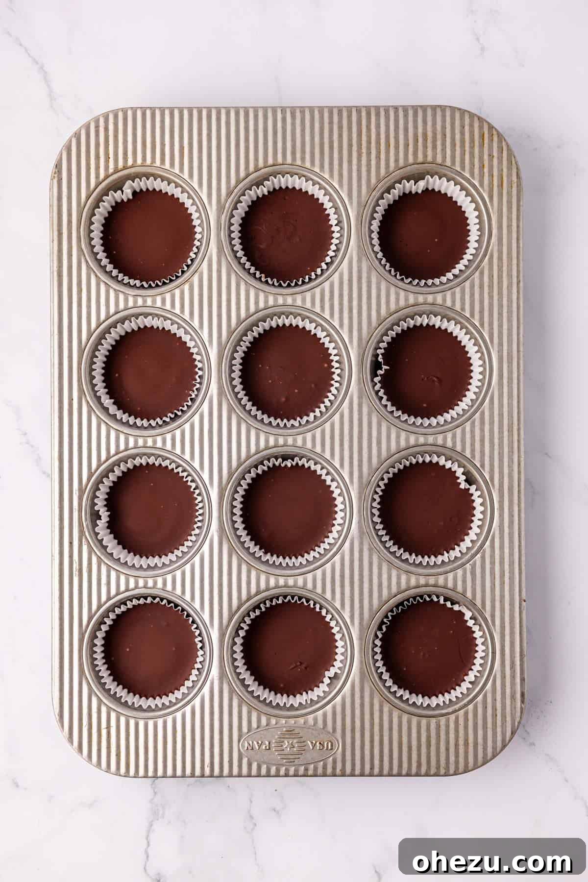 Protein peanut butter cups freshly topped with chocolate