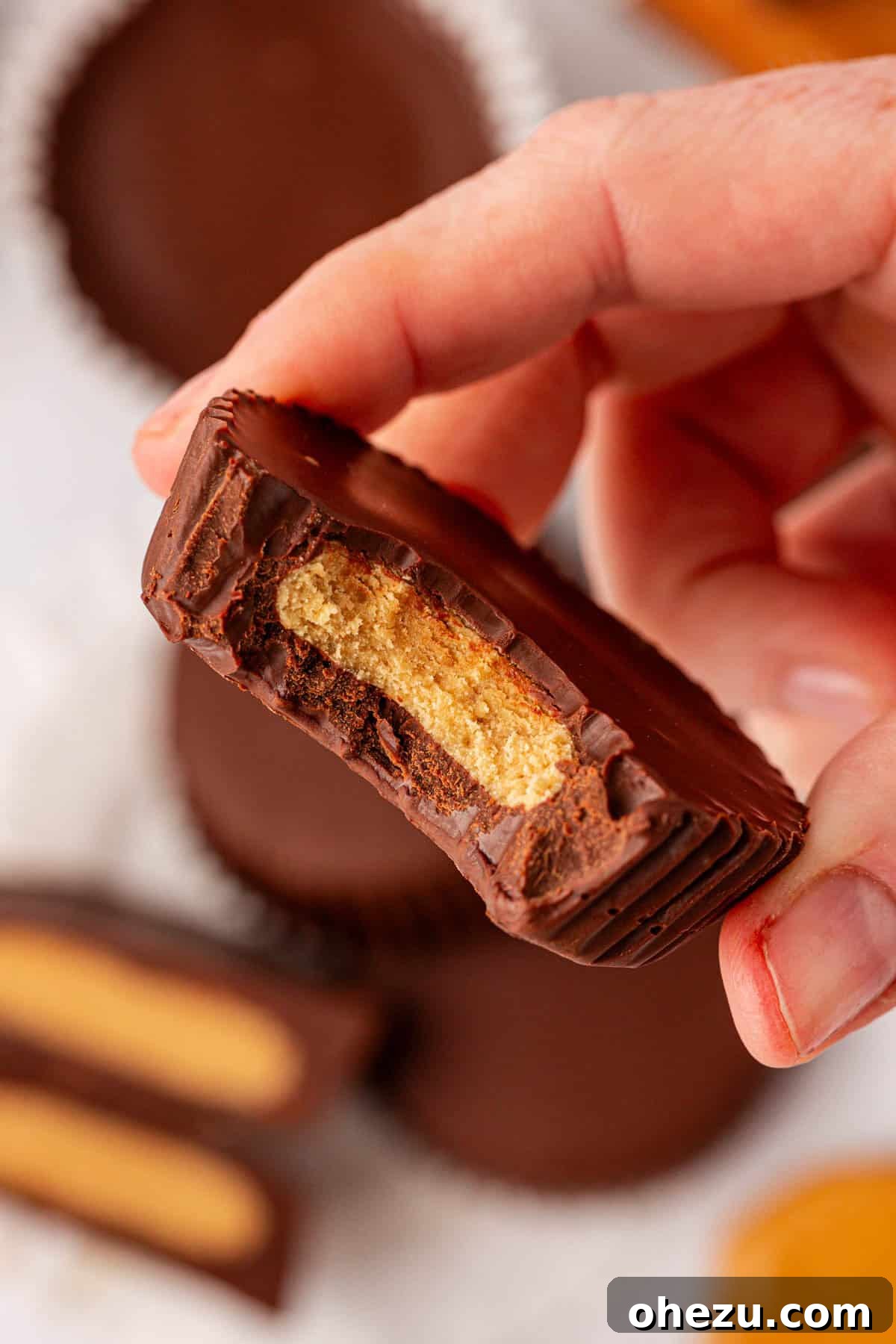 A stack of protein peanut butter cups, showing the rich chocolate and peanut butter layers