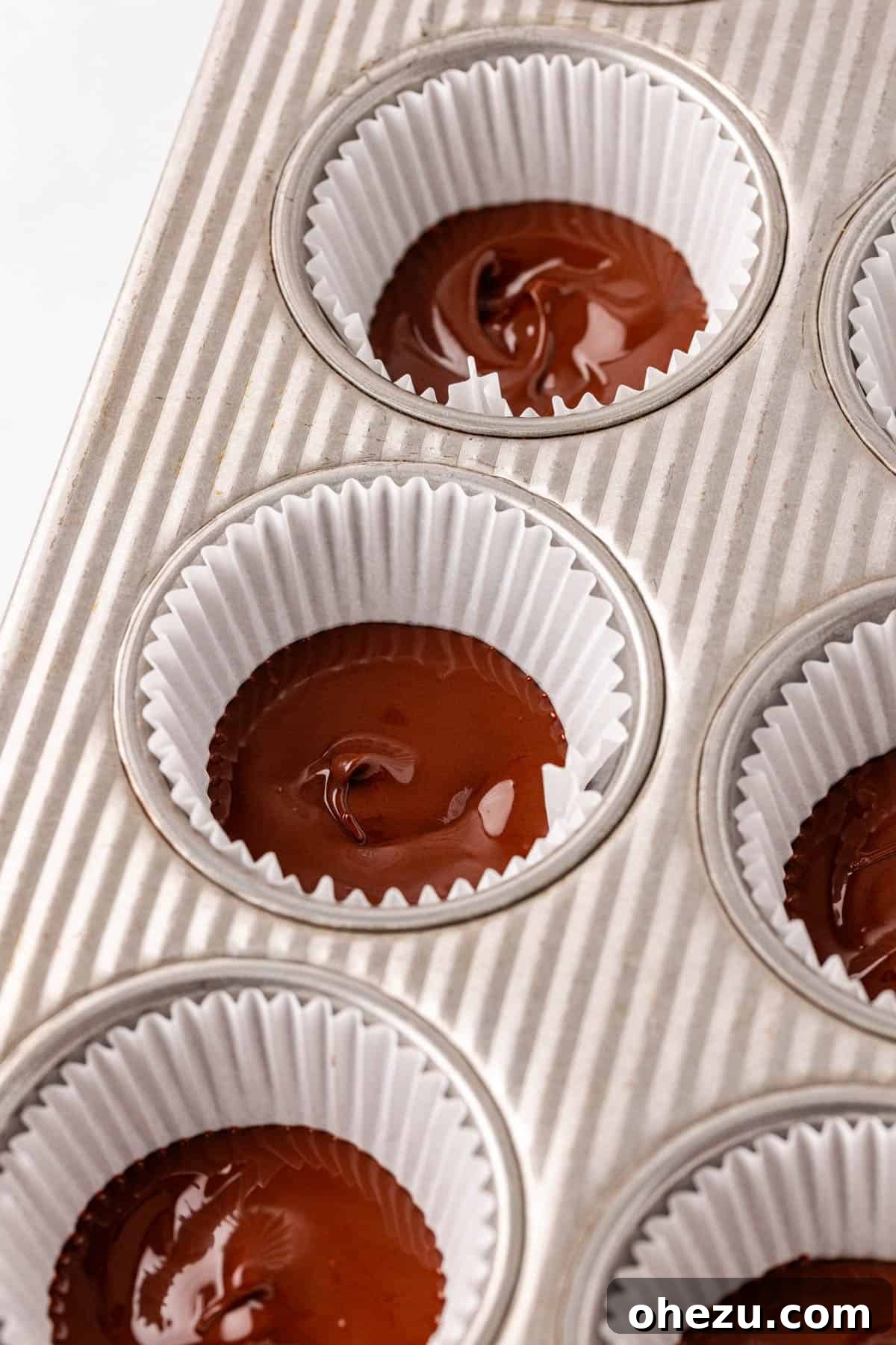 Melted chocolate spread evenly in a muffin tin liner