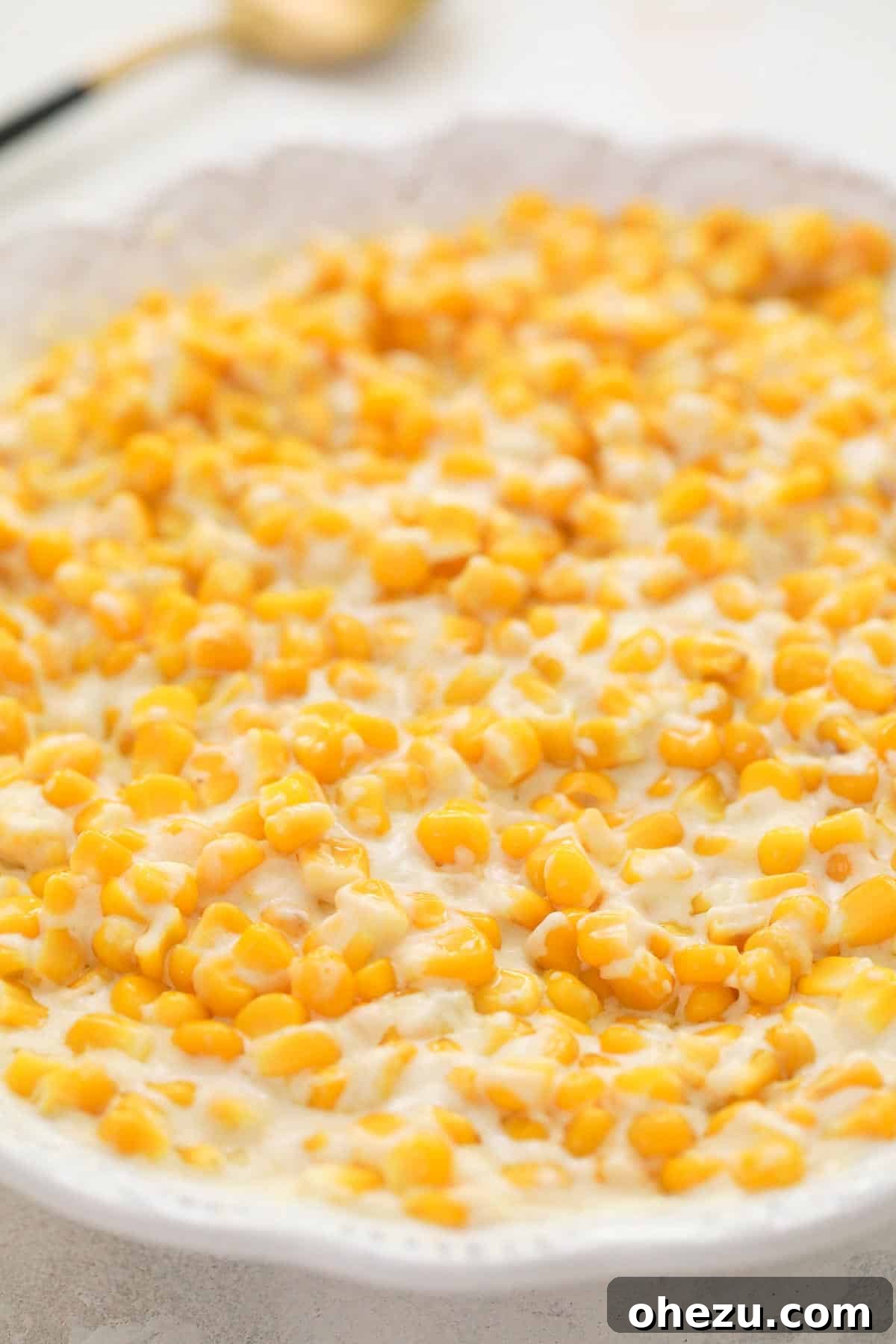 A serving dish filled with perfectly cooked creamed corn, ready to be enjoyed.