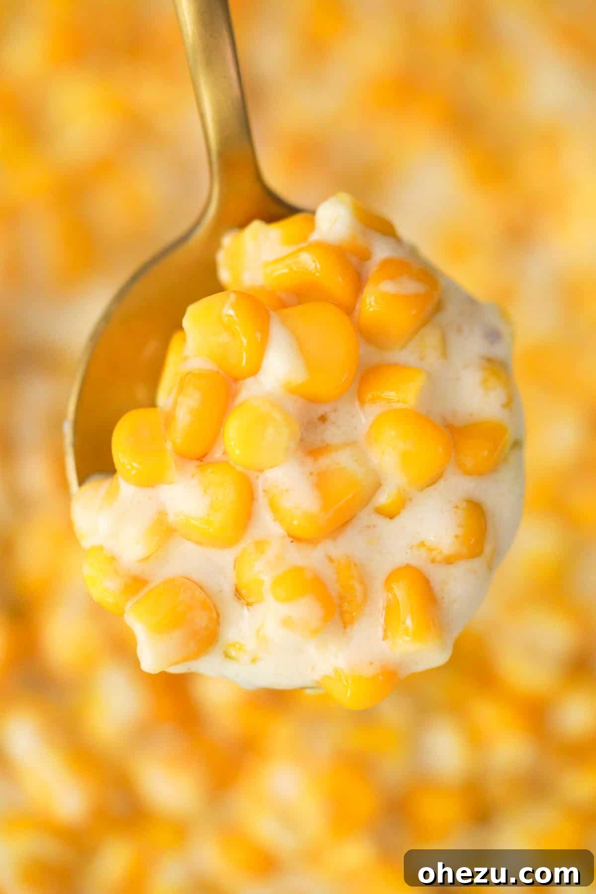 A spoon showing a generous scoop of creamed corn, emphasizing its delightful texture.