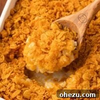 taking a scoop of funeral potatoes from the baking dish