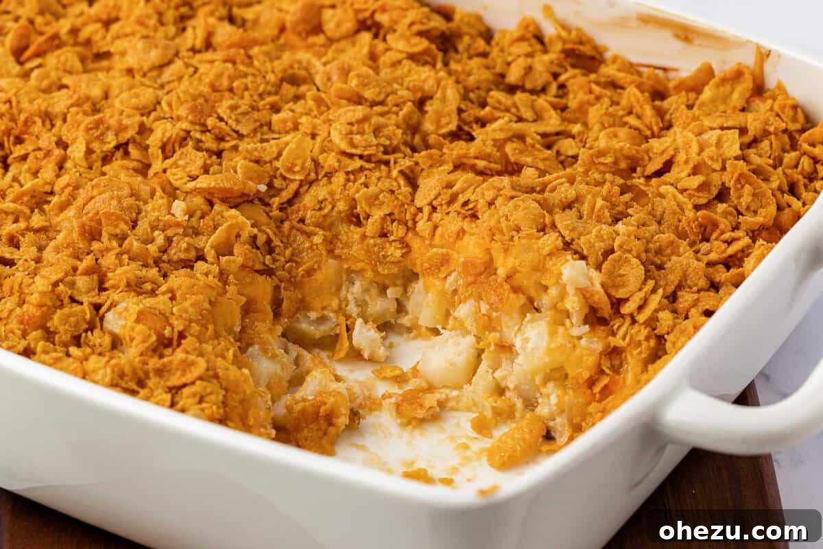 Close-up of baked cheesy potatoes with golden corn flakes on top