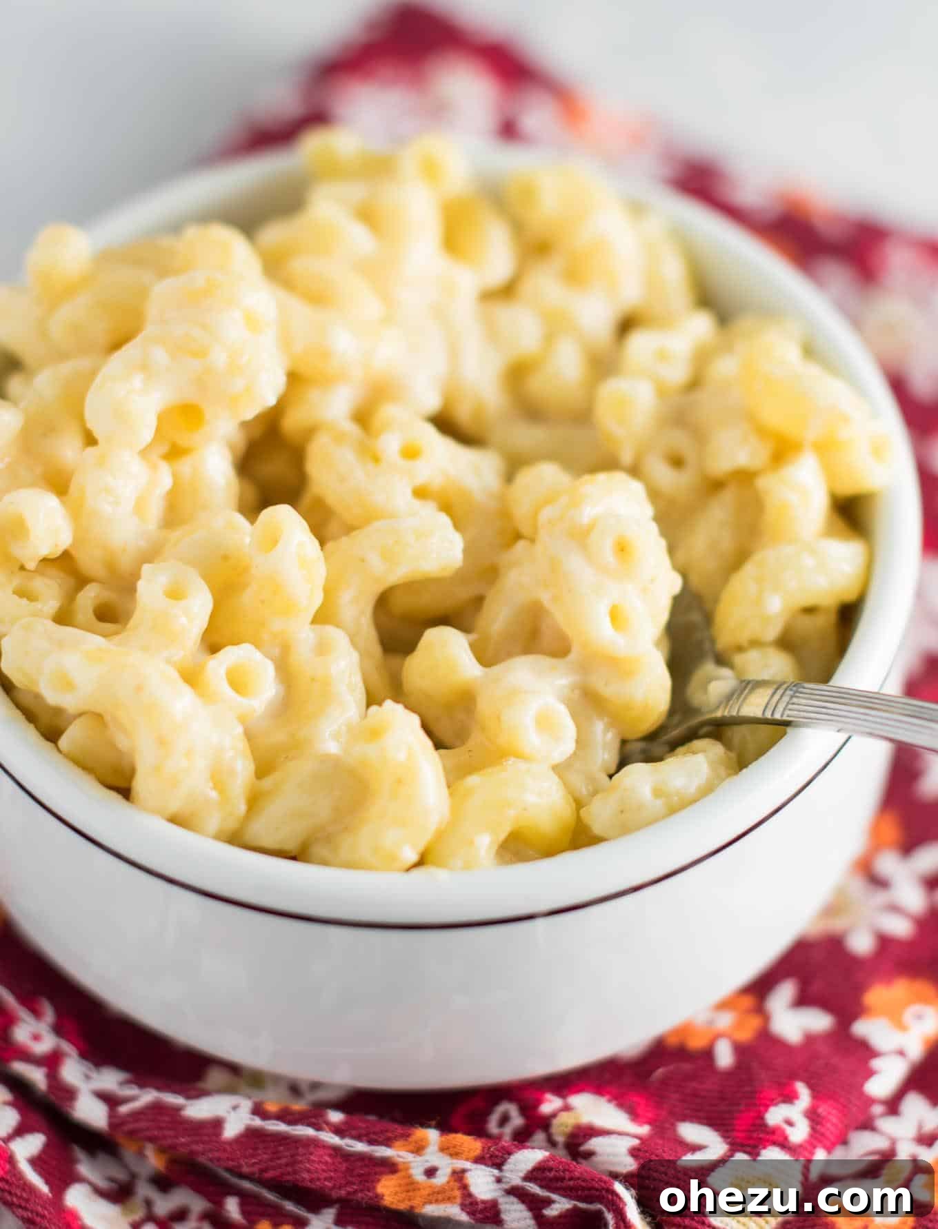 A bowl of creamy stove top mac and cheese garnished with freshly ground black pepper