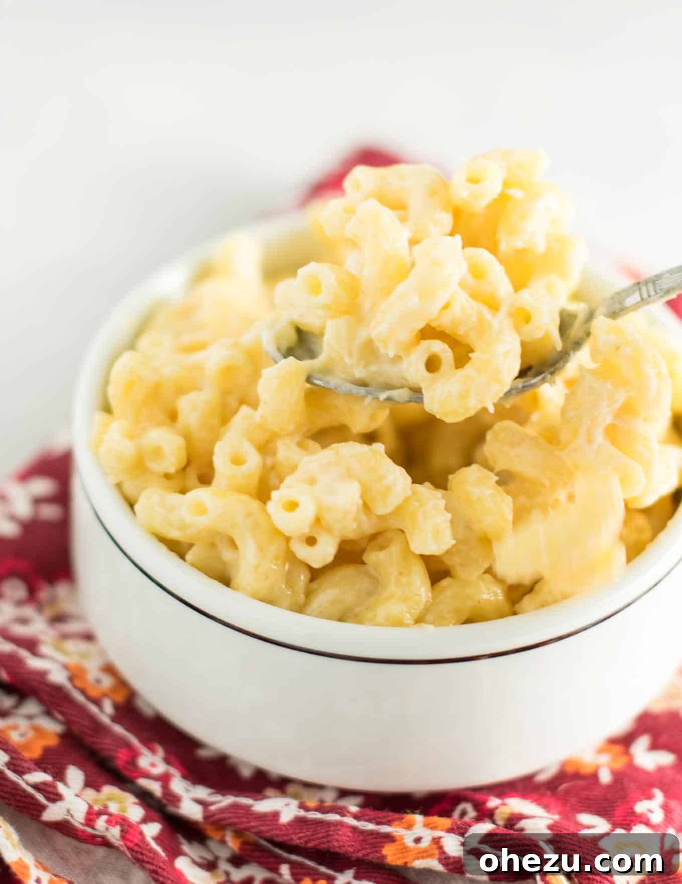 Toddler joyfully eating a piece of sharp cheddar cheese as an appetizer before mac and cheese