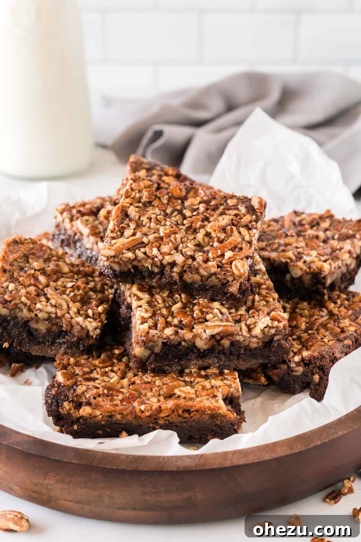 pecan pie brownies cut into squares and stacked on a plate