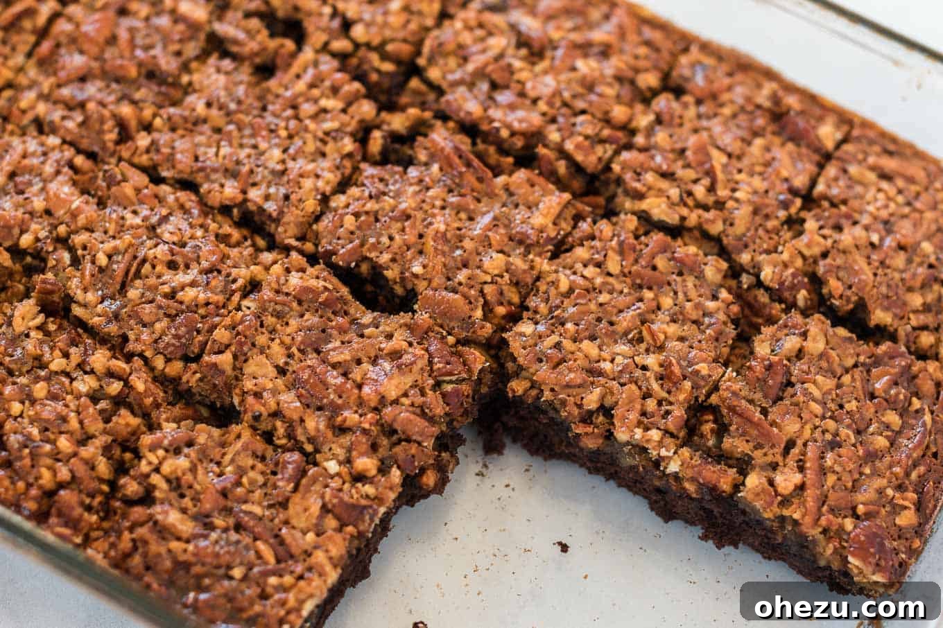 cut up pecan pie brownies in a glass baking dish with 4 removed