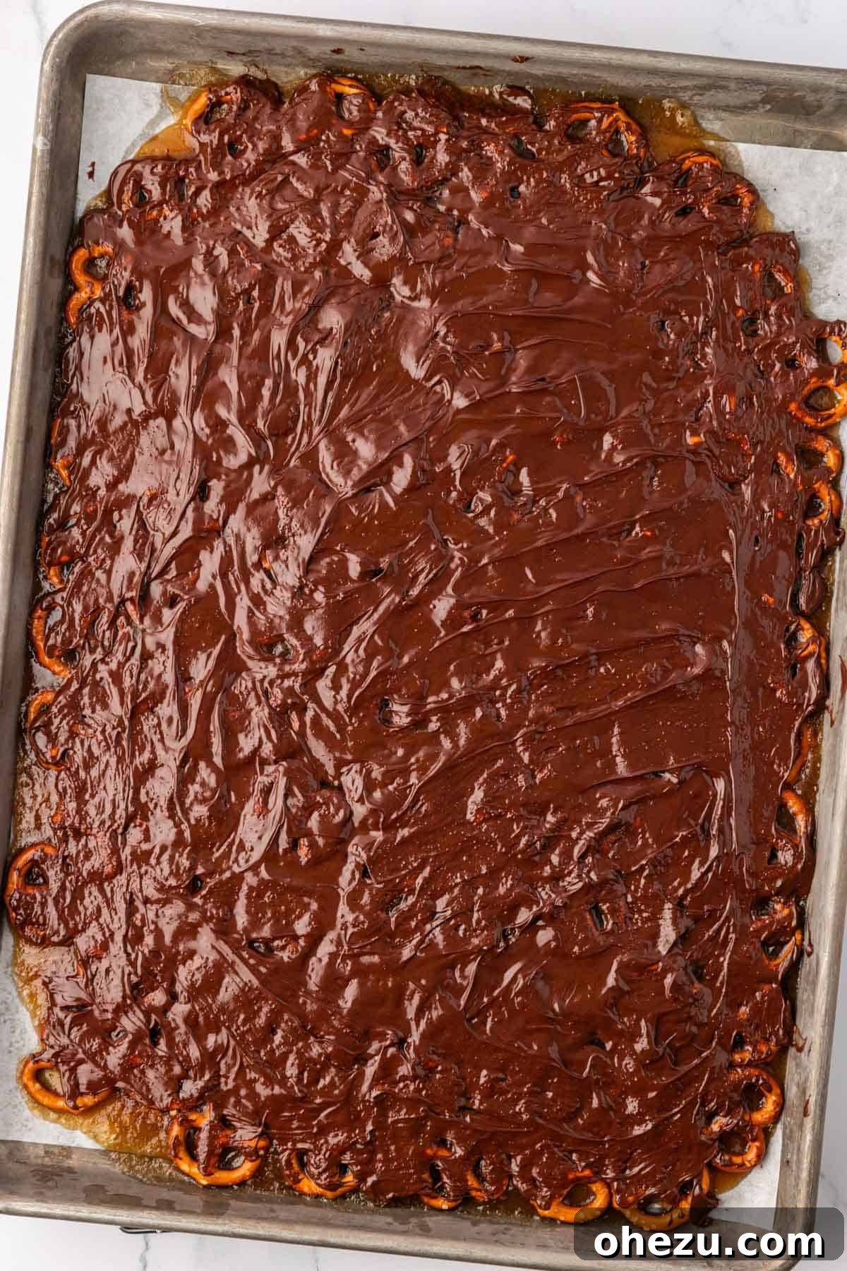 melted chocolate spread over toffee pretzels
