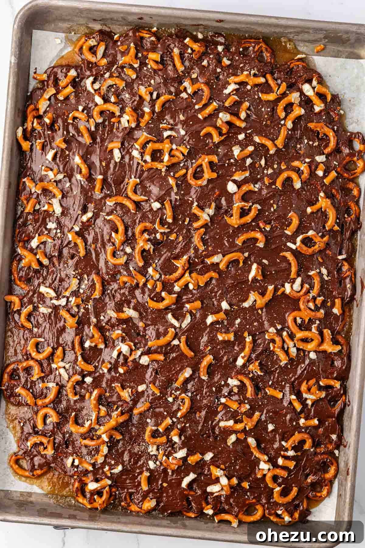 adding the crushed pretzels to the melted chocolate