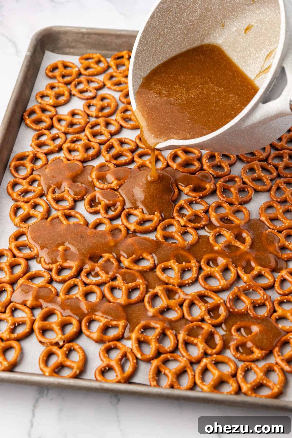 pouring the toffee over the pretzels