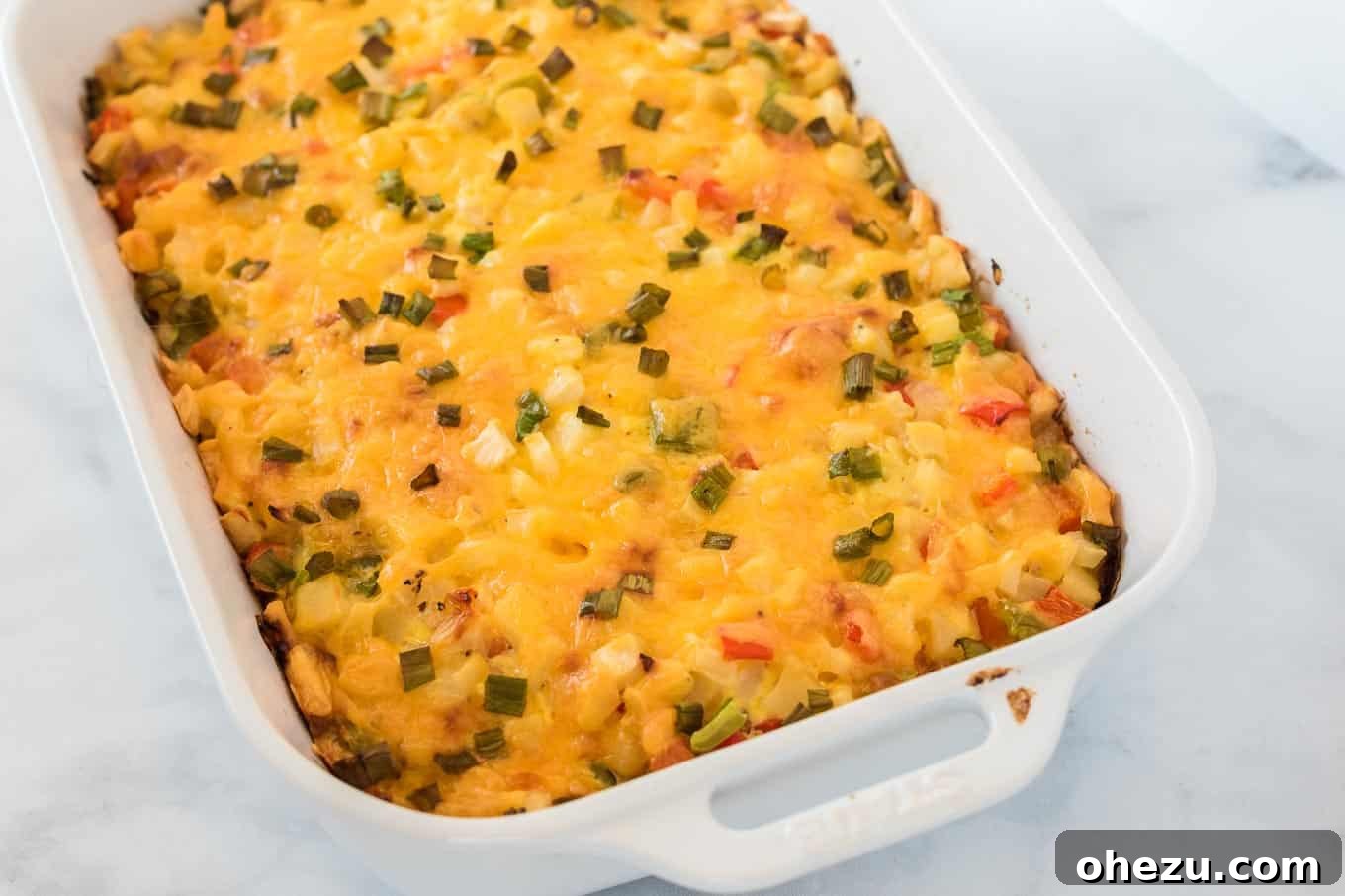 Sunrise Hash Brown Egg Bake 10 The finished baked hash brown egg casserole in a white dish, sliced into individual portions, ready to be served.