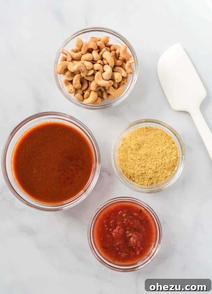 Four separate glass bowls showcasing the simple ingredients: cashews, nutritional yeast, salsa, and enchilada sauce