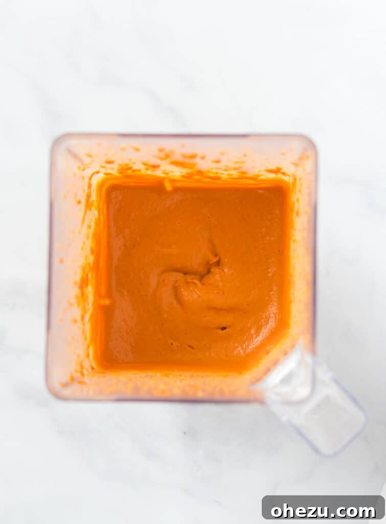 The blended vegan queso dip actively mixing in a high-speed blender