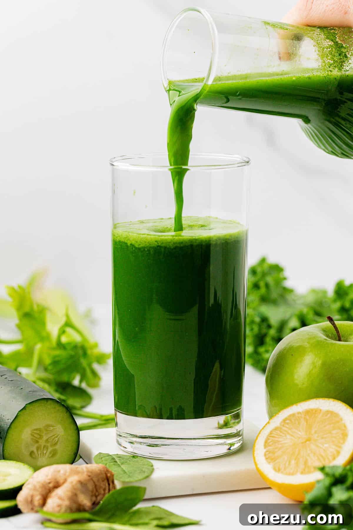 Vibrant Green Goodness 7 A hand pouring freshly made green juice from a pitcher into a clear glass.