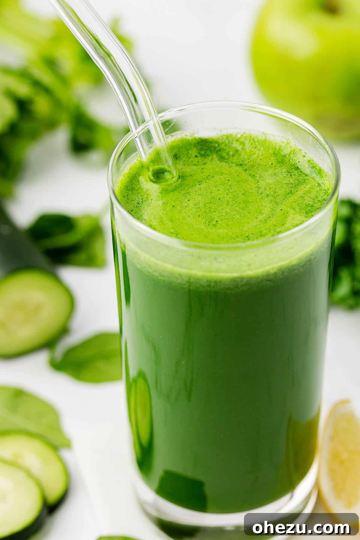 Vibrant Green Goodness 8 A glass of green juice with a straw, placed on a light wooden surface, ready to be enjoyed.