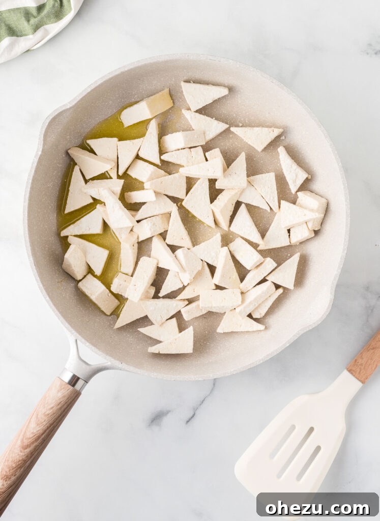 Adding the tofu to the oil in the skillet