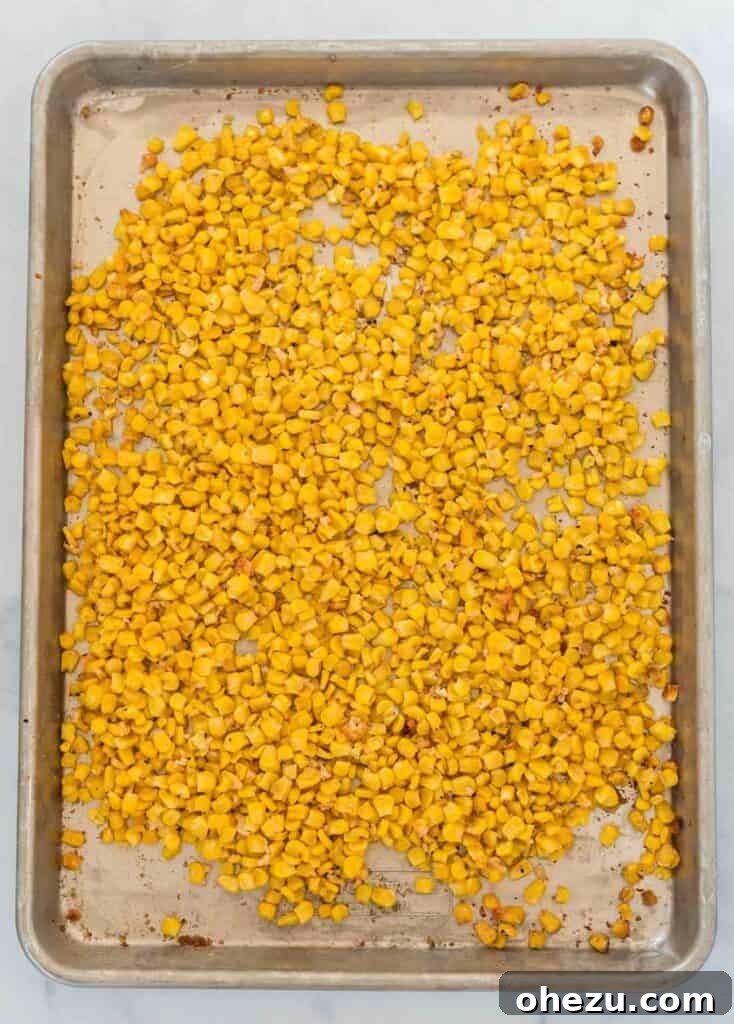 A second shot of roasted corn on a baking sheet, showing more browning and crispiness