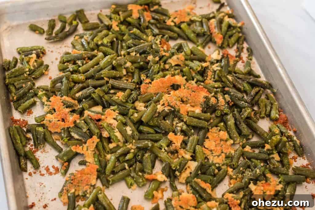 Roasted green beans with parmesan on a baking sheet, golden and crispy