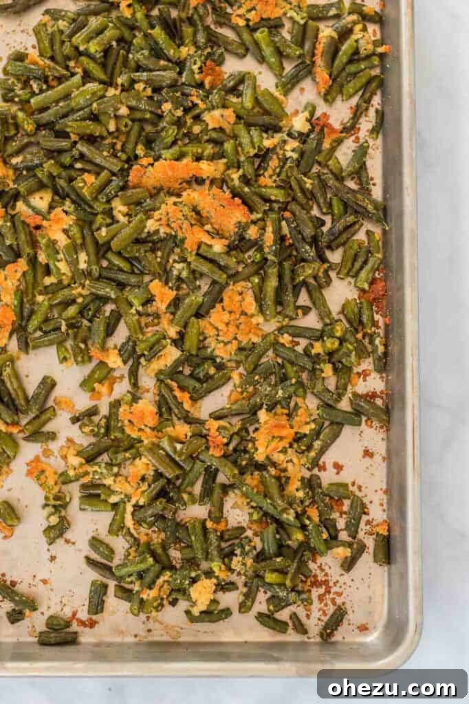 Frozen green beans spread on a baking sheet before roasting