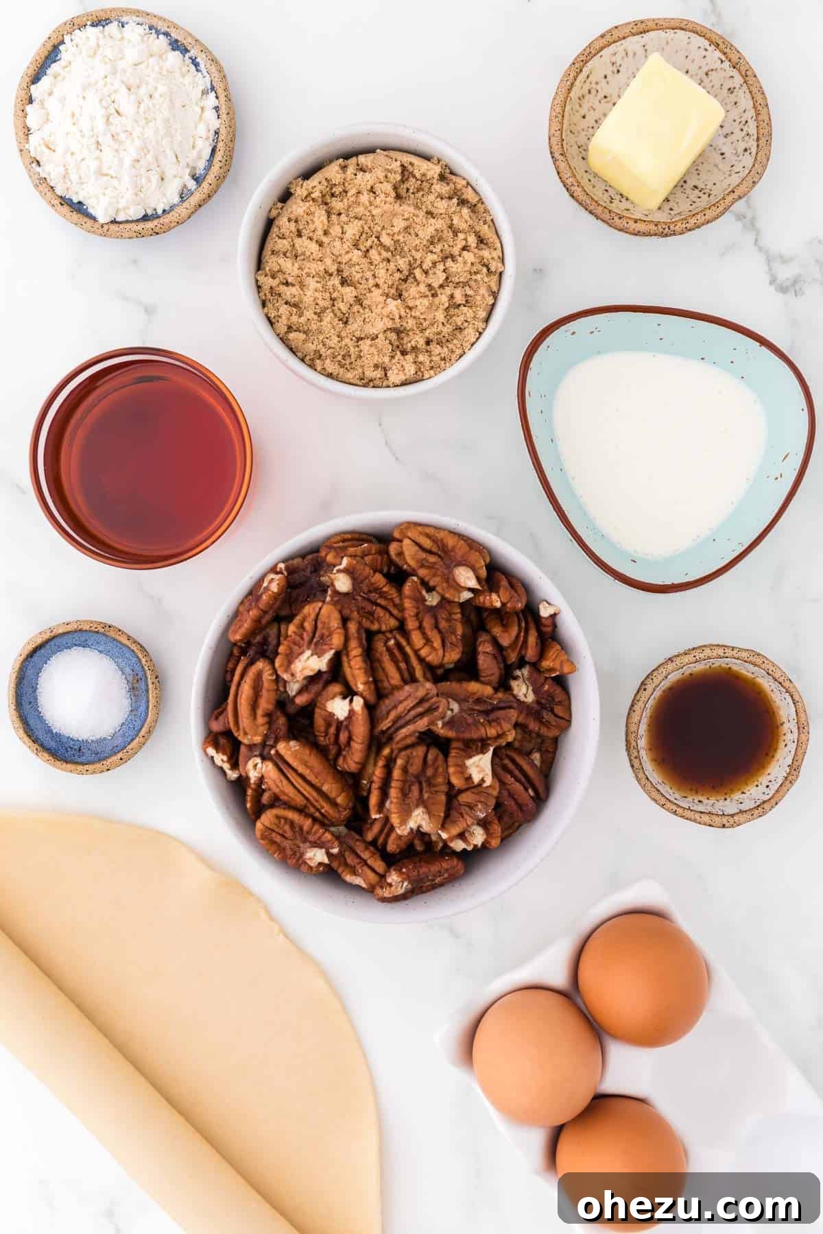 Collection of fresh ingredients arranged for making pecan pie without corn syrup, including pecans, maple syrup, eggs, and butter.