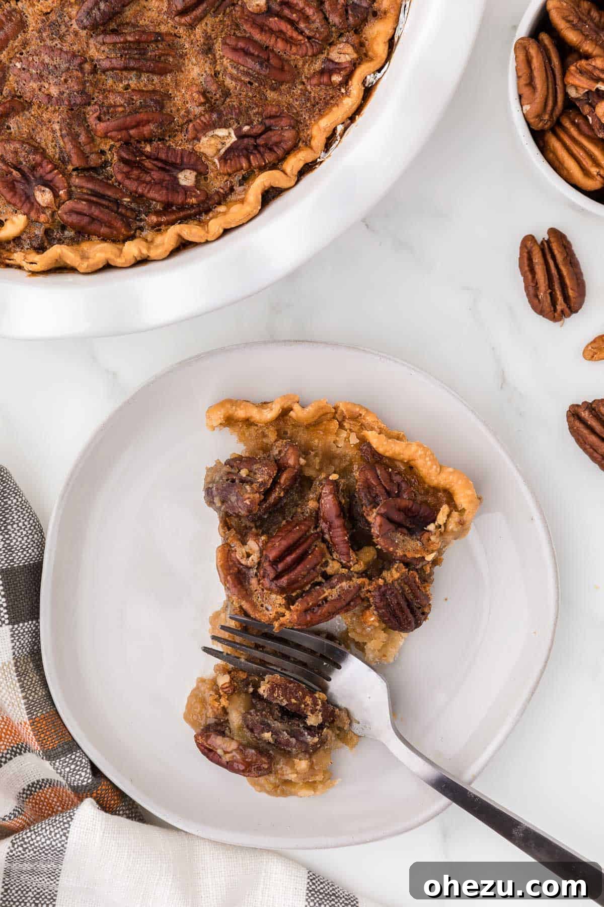 A single slice of Maple Pecan Pie artfully presented on a white plate, ready to be enjoyed.