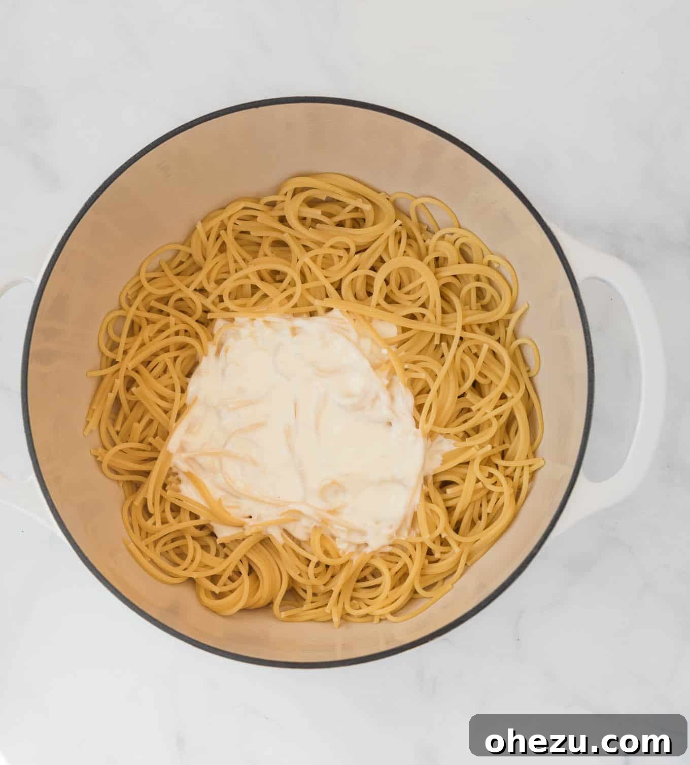 Spaghetti noodles generously coated with creamy cream cheese sauce