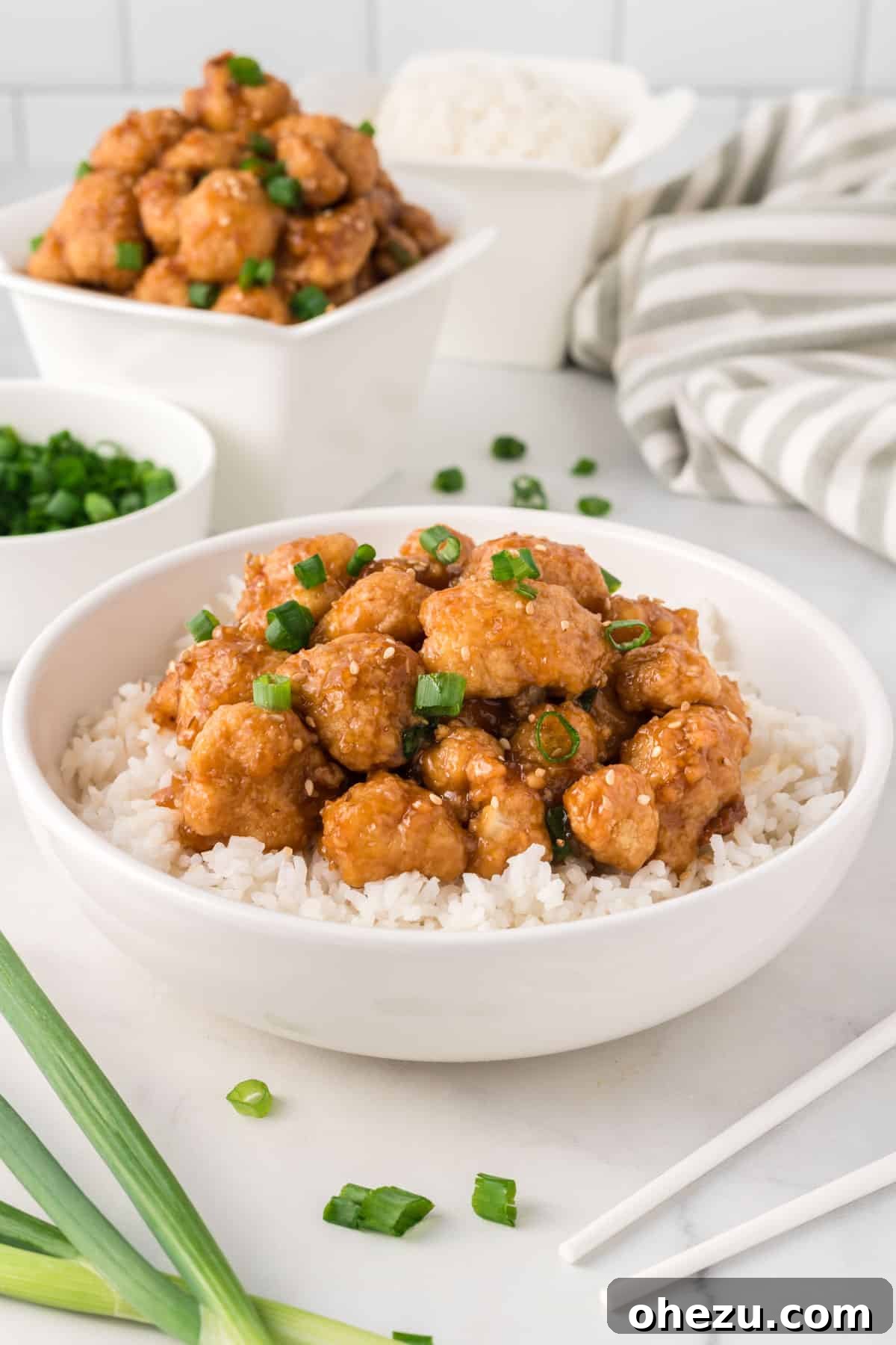 teriyaki cauliflower over rice in a white bowl