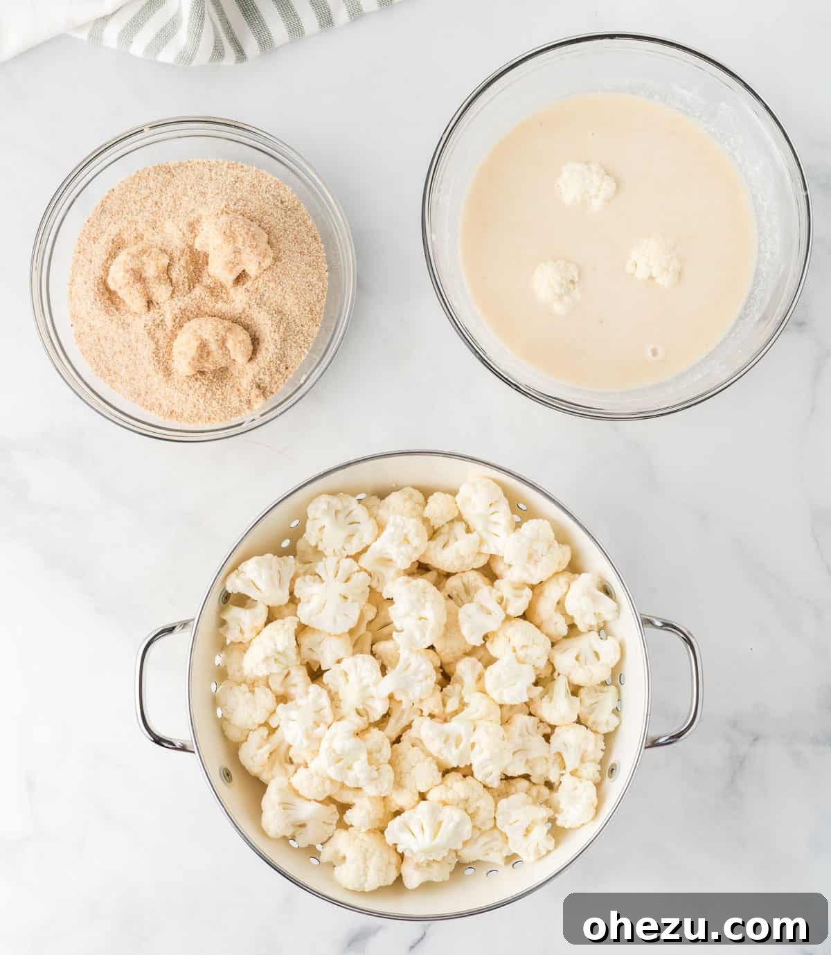 cauliflower being dipped in batter and breading