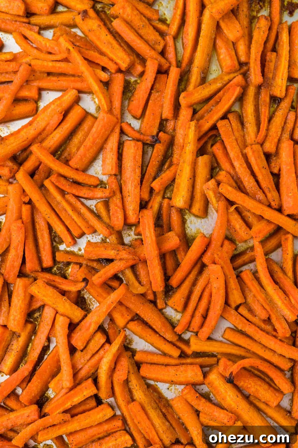 The Ultimate Roasted Carrots 12 A bounty of perfectly roasted carrots, golden and tender, gently cooling on a nonstick baking sheet after being removed from the oven.