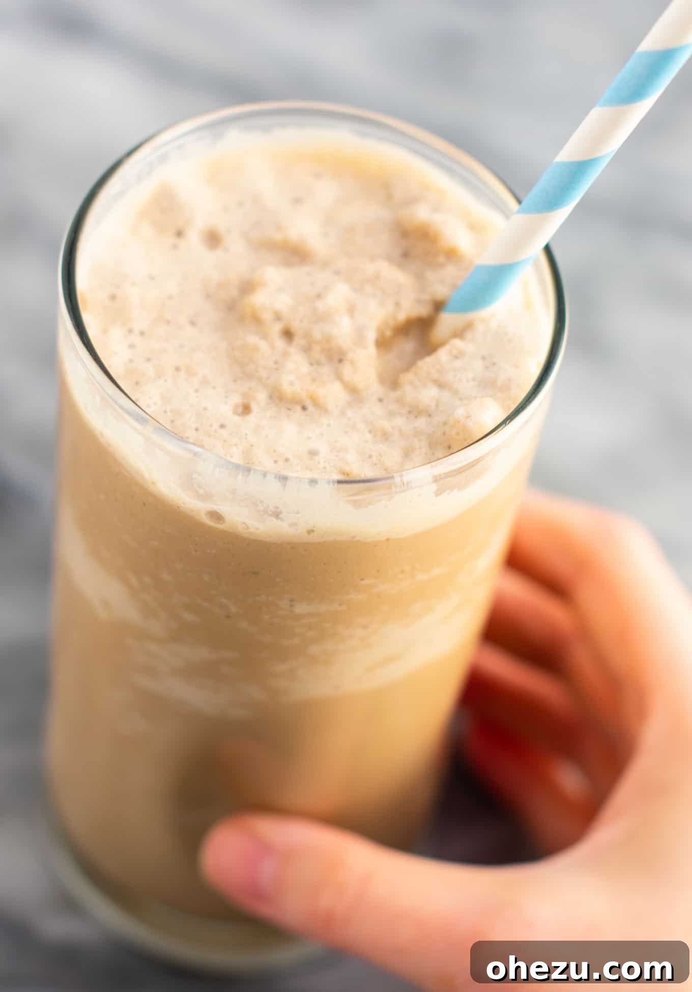 Homemade frozen coffee topped with generous whipped cream and chocolate drizzle