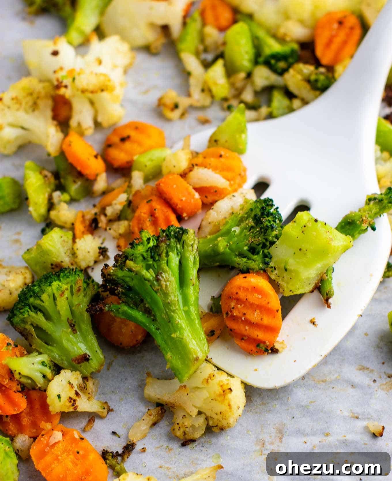 A serving of crispy air fried vegetables with a white spatula in a rustic bowl