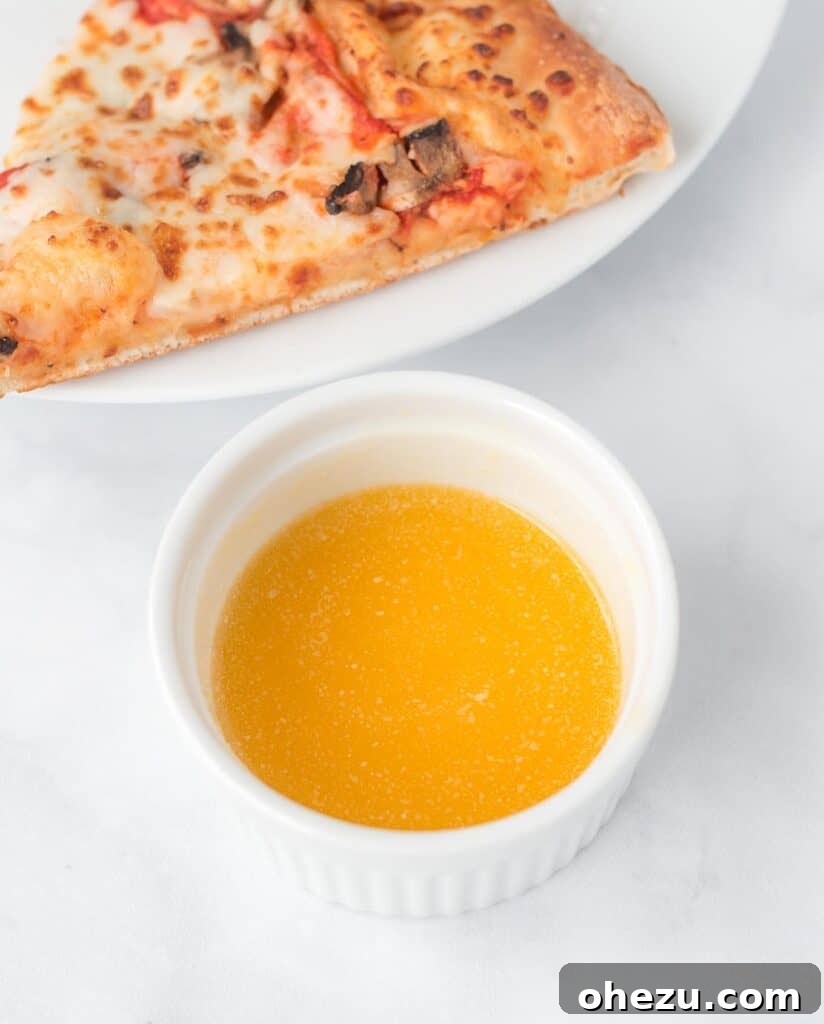 Close-up of a ramekin filled with golden-yellow, smooth garlic dipping sauce, ready for serving.