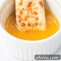 cheese stick being dipped in garlic sauce